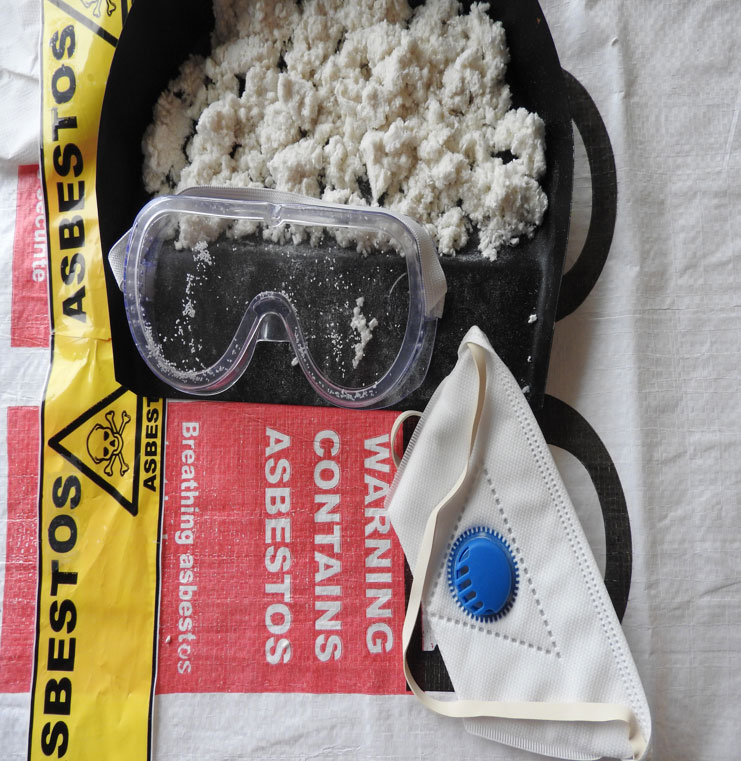 A pair goggles in front of a package of asbestos to represent an asbestos training course