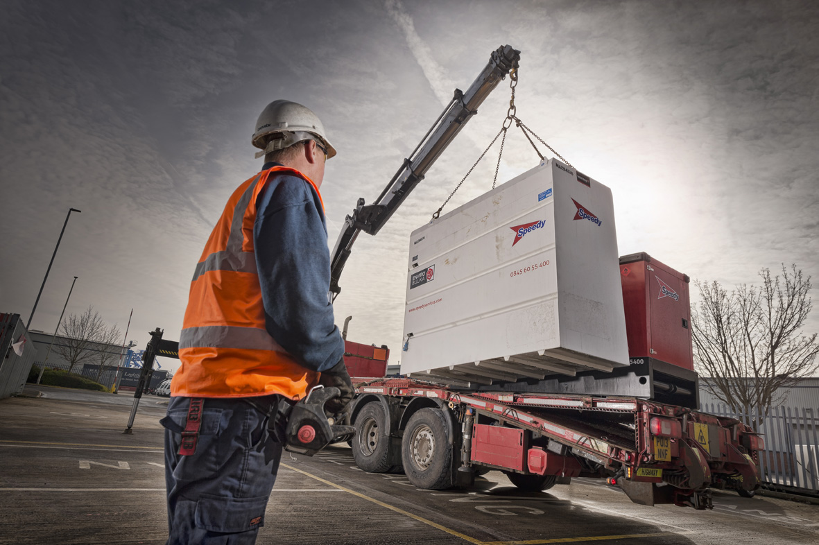 A lorry mounted crane moving cargo onto its loading bay