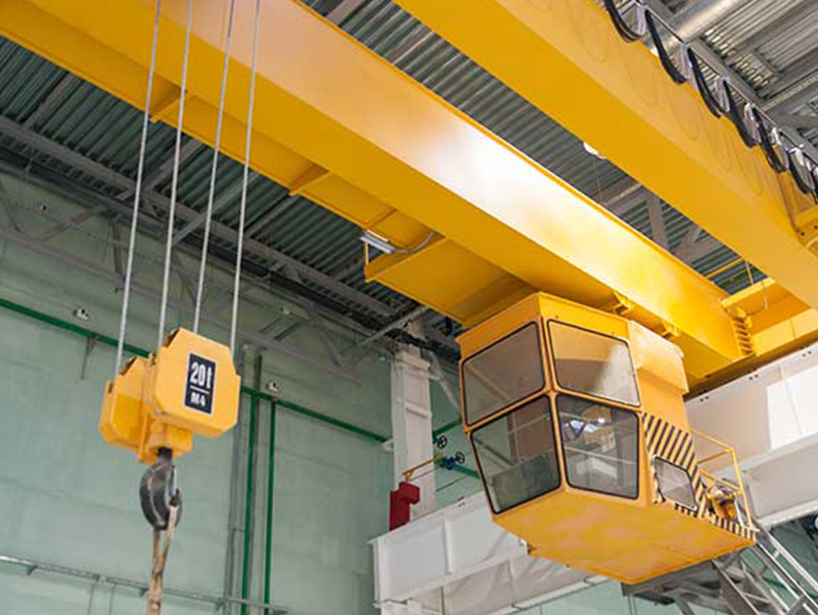 A yellow cab crane inside of a warehouse