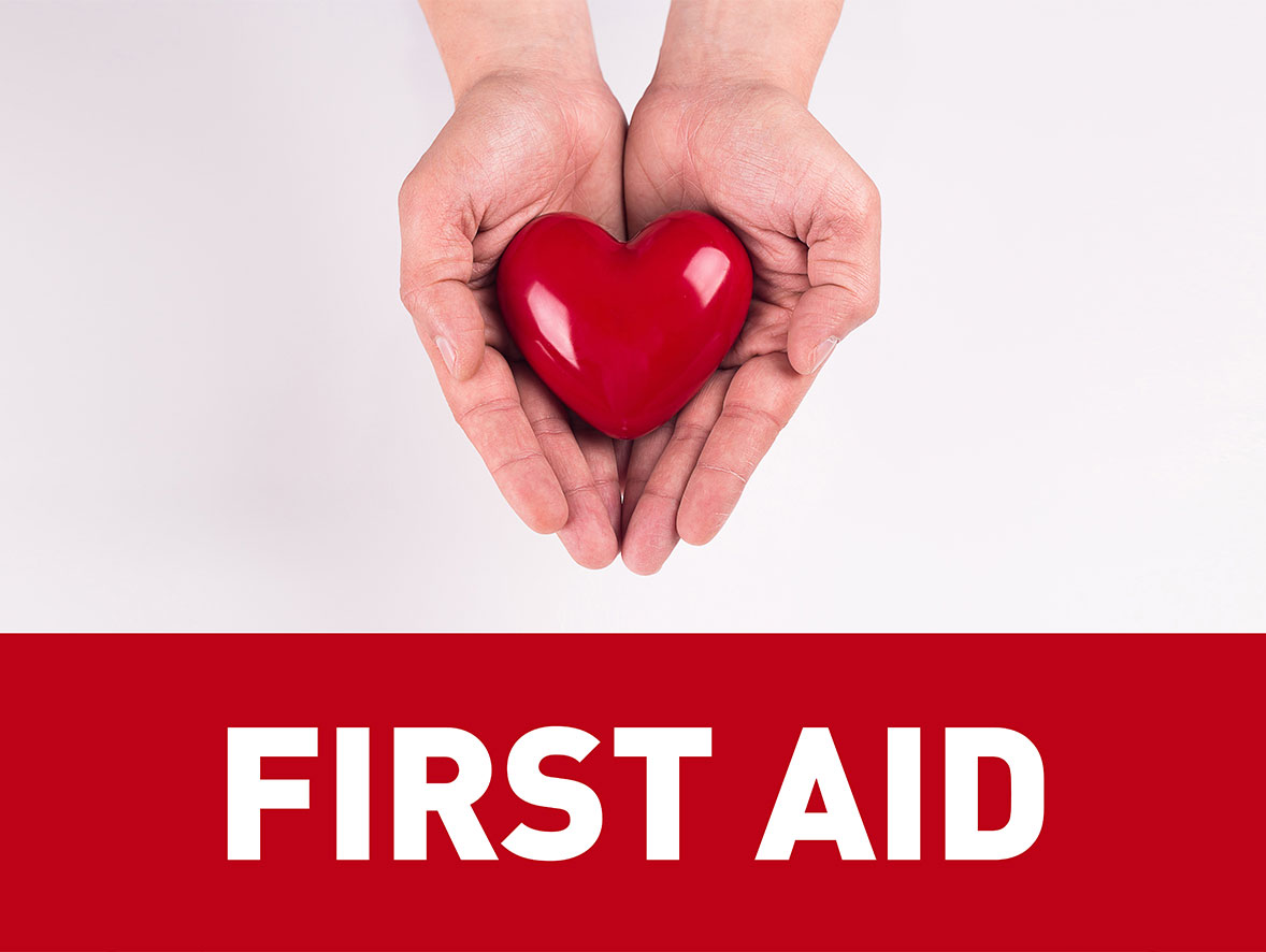 Two hands holding a love heart with the words first aid written underneath
